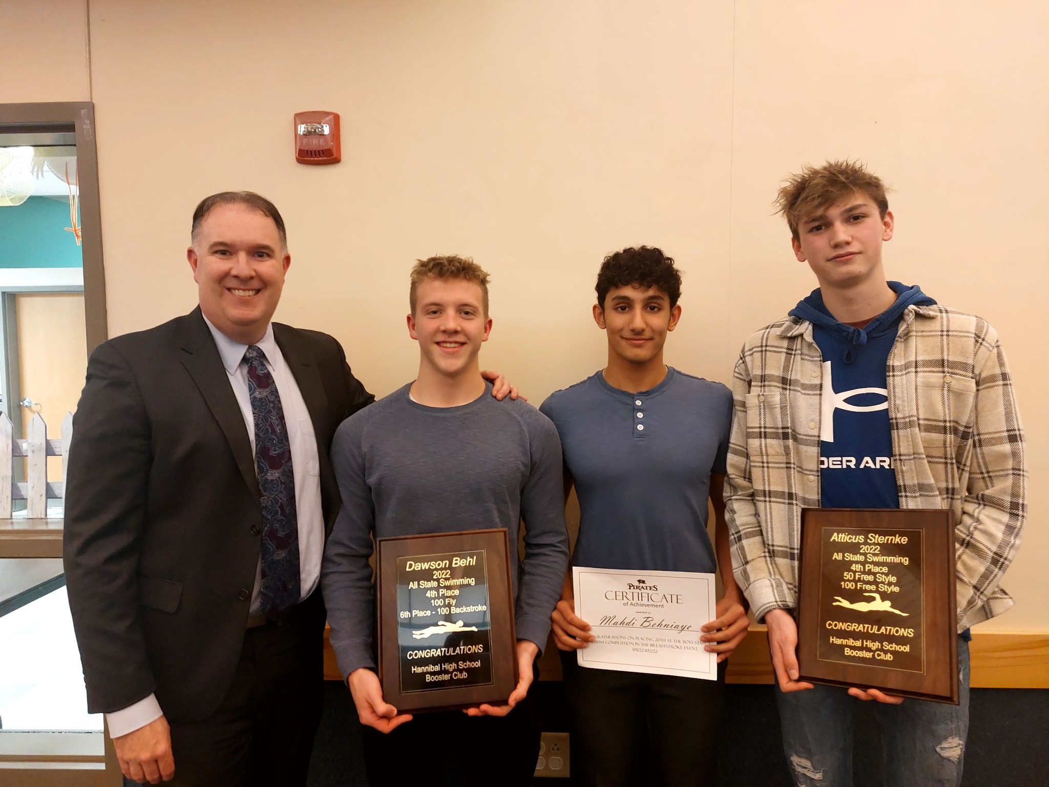 From left, President of the Hannibal School Board Michael Holliday, Dawson Biel, Madhi Behniaye and Atticus Sternke stand with their all-state honors for swimming.