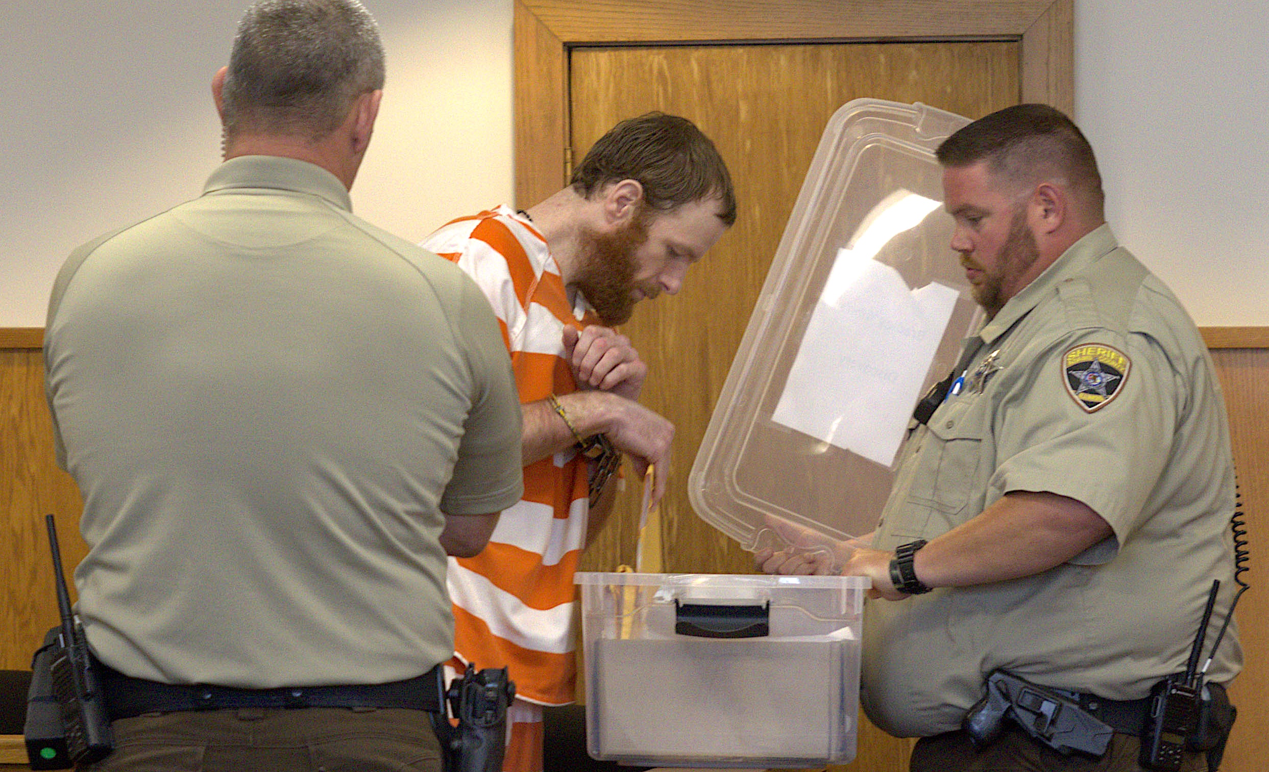 Bradley Yohn retrieves files under the watch of Adams County Court security officers during a motion hearing held Wednesday afternoon.
