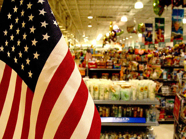An American flag is selectively focused in the foreground of this supermarket scene. Uses: consumerism issues, patriotism, etc.