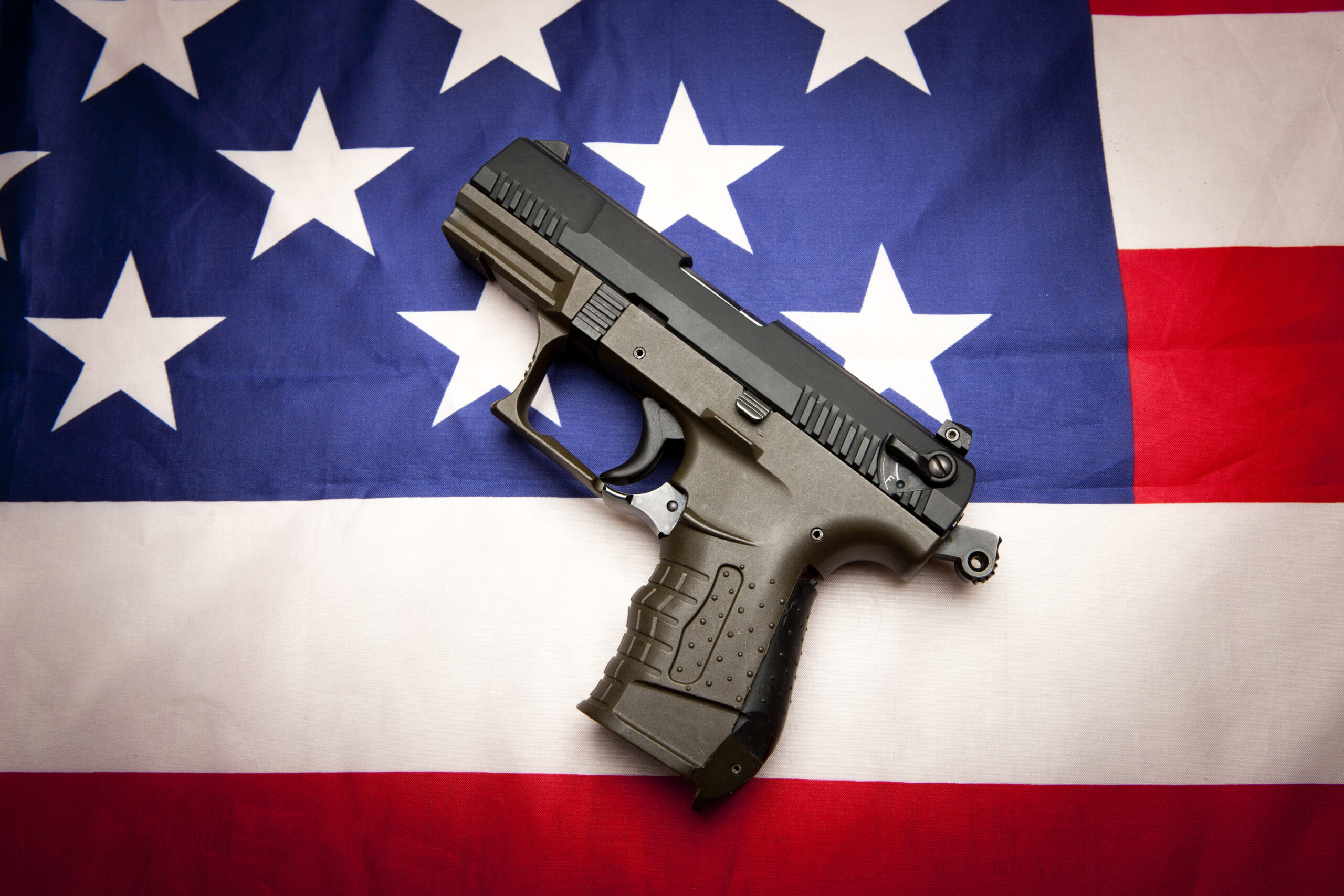 A concept image of liberty showing a pistol  on the American flag,