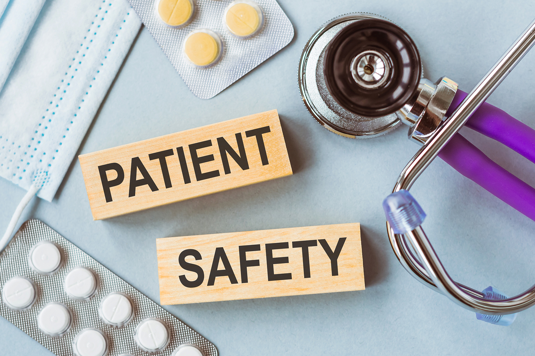 PATIENT SAFETY written on wooden cubes on medical background. PATIENT SAFETY written on wooden cubes on medical background.
