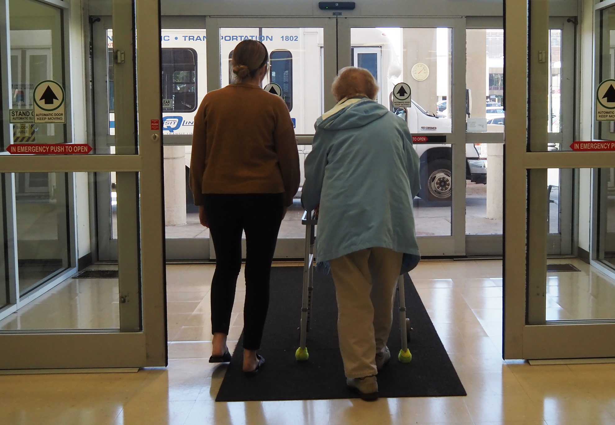 Vanessa Keppner (left), West Central Illinois Area Agency on Aging (WCIAN), walks former WCIAN employee Sandy Callahan to the bus in October 2024. 